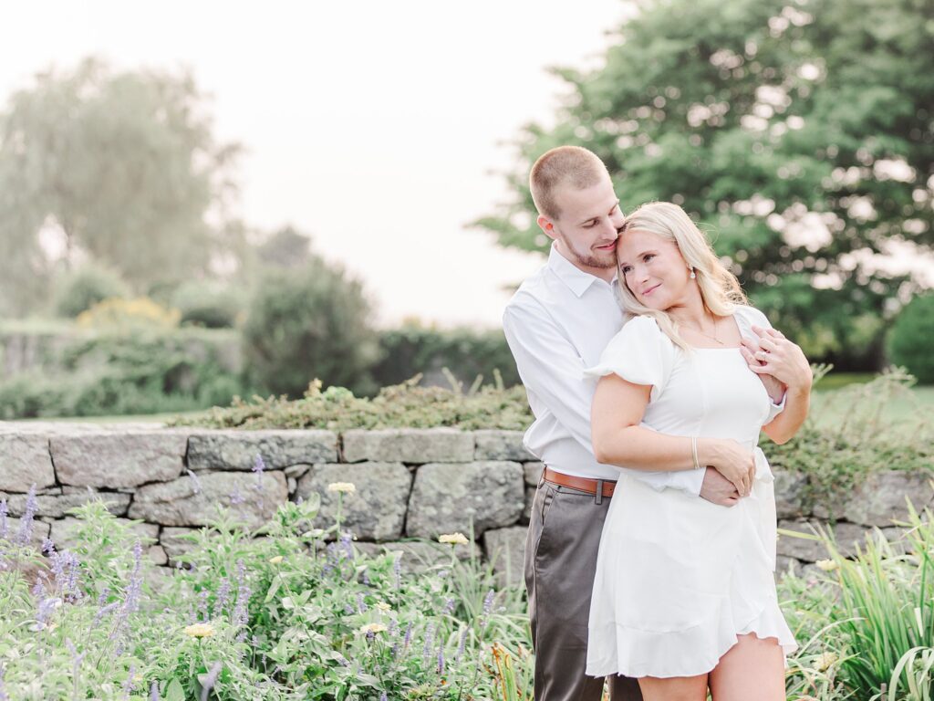 Eolia Mansion engagement photo of a couple standing together by a stone wall