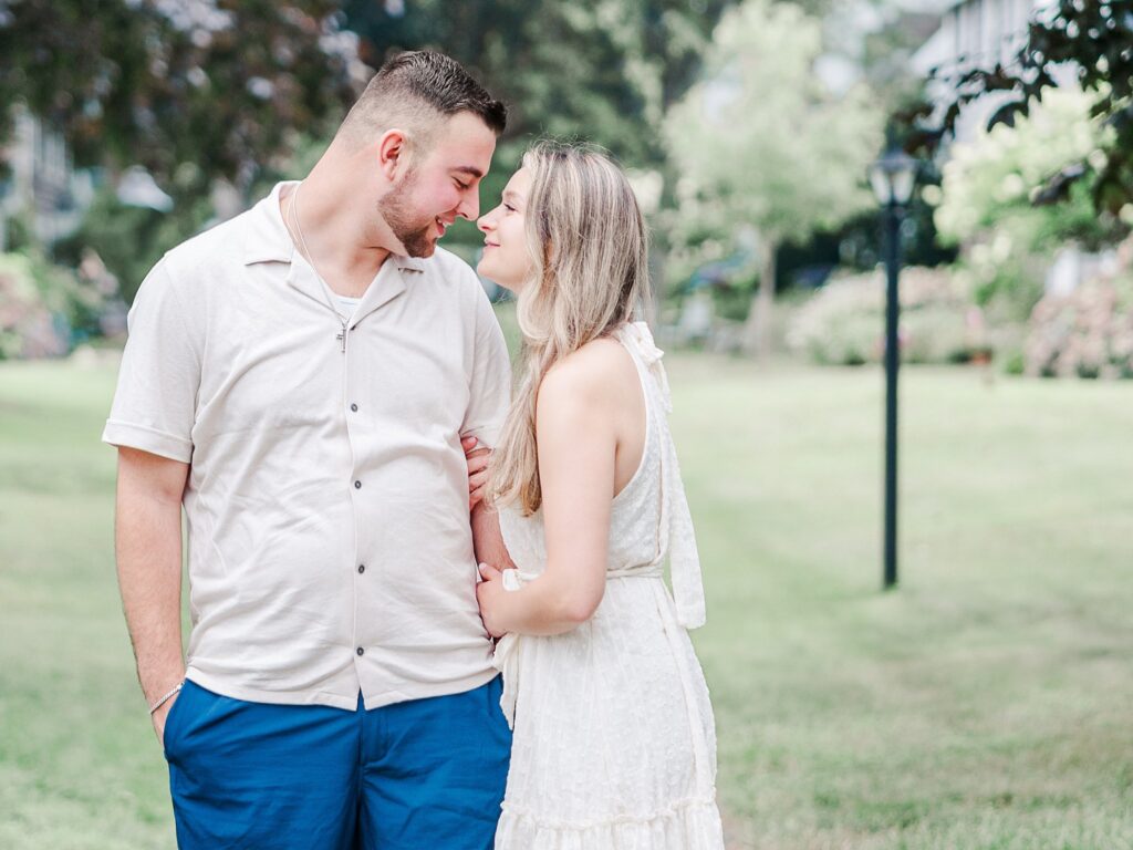 Engaged couple laughing together while walking along a quiet neighborhood path near the beach in Clinton Connecticut